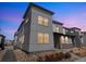 Modern two-story home showcasing a sleek design with large windows and neat landscaping at dusk at 19197 E 64Th Ave, Denver, CO 80249