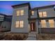 Modern townhome exterior showcasing clean lines, a red front door, and low-maintenance landscaping at 19197 E 64Th Ave, Denver, CO 80249