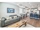 Open-concept living area with hardwood floors and a modern kitchen featuring an island and stainless steel appliances at 19197 E 64Th Ave, Denver, CO 80249