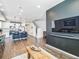 Open-concept living space with hardwood floors and a modern kitchen island; stairs leading to the second floor at 19197 E 64Th Ave, Denver, CO 80249