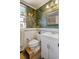 Charming bathroom featuring vintage-inspired wallpaper, white vanity with sink, and a decorative mirror at 780 Campo St, Denver, CO 80221