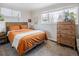 Bright bedroom featuring an orange bed set, wooden furniture, and natural light at 780 Campo St, Denver, CO 80221