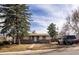 Cozy single-story home with rock facade and trimmed front yard, featuring a well-maintained lawn and mature trees at 780 Campo St, Denver, CO 80221
