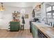 Bright kitchen with open shelving, green cabinetry, wood countertops, and black appliances at 780 Campo St, Denver, CO 80221