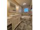 Bright bathroom features stone-look tiles and a vanity with marble countertop and a large framed mirror at 2357 E Mineral Ave, Centennial, CO 80122