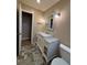 A modern bathroom with decorative vanity, framed mirror, updated lighting and stone look floor tiles at 2357 E Mineral Ave, Centennial, CO 80122