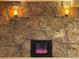 Stone fireplace featuring sconces, decorative mantle, and electric fire in finished basement at 2357 E Mineral Ave, Centennial, CO 80122