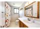 Bathroom with a colorful shower curtain, white tile, and a wood-trimmed mirror at 3111 Troy St, Aurora, CO 80011