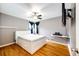 Clean bedroom featuring a white bed with storage, hardwood floors, and modern fan at 3111 Troy St, Aurora, CO 80011