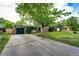 View of house featuring driveway, lawn, and mature trees at 3111 Troy St, Aurora, CO 80011