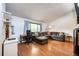 Bright living room with hardwood floors, large sectional sofa and desk area at 3111 Troy St, Aurora, CO 80011