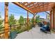 Backyard patio area with wooden pergola, string lights, and outdoor seating at 6046 Gilbert Way, Golden, CO 80403