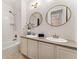 Bathroom featuring double sinks, modern fixtures, stylish lighting, and a shower over tub at 6046 Gilbert Way, Golden, CO 80403