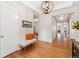 Bright foyer featuring hardwood floors, a decorative light fixture, and a charming bench with orange pillows at 6046 Gilbert Way, Golden, CO 80403