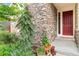 Inviting front porch with stone accents, red door, and decorative plants, creating a warm welcome at 6046 Gilbert Way, Golden, CO 80403