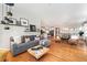 Open-concept living room with hardwood floors and stylish decor flows into the dining area and kitchen at 6046 Gilbert Way, Golden, CO 80403