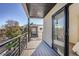 A spacious balcony with metal railings and wooden floors with a sliding glass door to the inside at 1715 Grove St, Denver, CO 80204
