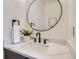 Stylish bathroom features a modern vanity with a quartz countertop and round mirror at 1715 Grove St, Denver, CO 80204