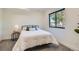 Cozy bedroom showcasing a black-framed window and a plush, white textured comforter at 1715 Grove St, Denver, CO 80204