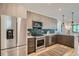 Modern kitchen with stainless steel appliances, tile backsplash, and view into the open living area at 1715 Grove St, Denver, CO 80204