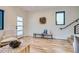 Open-concept living area with hardwood floors, neutral decor, and a staircase to the side at 1715 Grove St, Denver, CO 80204