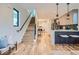 Bright open-concept space with hardwood floors, staircase, and modern kitchen with sleek countertops at 1715 Grove St, Denver, CO 80204