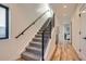 Hallway features a carpeted staircase with modern railings and light wood flooring at 1715 Grove St, Denver, CO 80204