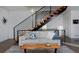 A bright living room with a modern staircase, comfortable sofa, and a unique wooden coffee table on a gray rug at 2536 W 33Rd Ave, Denver, CO 80211