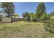Overiew of the spacious backyard, complete with a shed, grassy area, and mature trees at 1750 S Dale Ct, Denver, CO 80219
