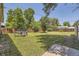 Large fenced backyard featuring lush lawn, mature trees, providing privacy and ample space for activities at 1750 S Dale Ct, Denver, CO 80219