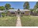 Charming brick home with a metal roof, awnings, and a quaint front yard at 1750 S Dale Ct, Denver, CO 80219