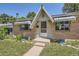 Charming home exterior with brick accents, decorative awnings, and well-manicured front yard at 1750 S Dale Ct, Denver, CO 80219