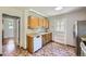 Cozy kitchen featuring wood cabinets, a dishwasher, and direct access to the backyard at 1750 S Dale Ct, Denver, CO 80219