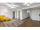 Spacious basement area with tile and laminate flooring, yellow chair, and multiple doorways at 6193 Brantly Ave, Castle Rock, CO 80104