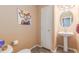 Half-bathroom with pedestal sink and tiled floor and fun artwork at 6193 Brantly Ave, Castle Rock, CO 80104