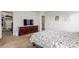 Bedroom with floral bedding, a media cabinet with a flat screen TV, and access to a walk-in closet at 6193 Brantly Ave, Castle Rock, CO 80104