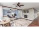 Open living room boasts lots of light, wood beams, a decorative fireplace, and stylish furnishings at 6193 Brantly Ave, Castle Rock, CO 80104