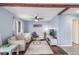 Comfortable living room is highlighted by wood beam, fireplace, tile flooring and big windows at 6193 Brantly Ave, Castle Rock, CO 80104