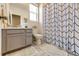 Bathroom featuring tiled floors, patterned shower curtain, and vanity with ample storage at 929 Honey Berry Ct, Elizabeth, CO 80107