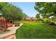 Spacious backyard with a lush lawn, mature trees, and cozy seating area at 1205 W 11Th Ct, Broomfield, CO 80020