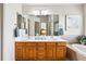 Elegant bathroom featuring a double vanity, large mirror, and a separate tub at 1205 W 11Th Ct, Broomfield, CO 80020