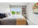 Well-lit bedroom featuring a comfy bed, window views, and practical built-in shelving at 1205 W 11Th Ct, Broomfield, CO 80020