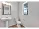 Powder room featuring pedestal sink, modern fixtures, and wood-look floors at 10661 Reunion Pkwy, Commerce City, CO 80022