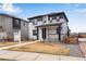 Charming two-story home featuring a covered front porch and modern gray and white color scheme at 10661 Reunion Pkwy, Commerce City, CO 80022