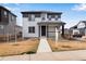 Charming two-story home featuring a covered front porch and modern gray and white color scheme at 10661 Reunion Pkwy, Commerce City, CO 80022
