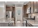 Kitchen featuring island with granite countertop, stainless steel appliances, and dark cabinets at 10661 Reunion Pkwy, Commerce City, CO 80022