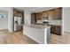 Kitchen island with granite countertop, stainless steel appliances, and brown cabinets at 10661 Reunion Pkwy, Commerce City, CO 80022