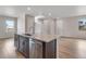 Island with granite countertop, stainless steel dishwasher, and dark brown cabinets at 10661 Reunion Pkwy, Commerce City, CO 80022