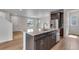 Kitchen island with stainless steel appliances, cabinets, and a view of the living room at 10661 Reunion Pkwy, Commerce City, CO 80022