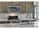 A modern kitchen features stainless steel appliances and a speckled granite countertop at 10661 Reunion Pkwy, Commerce City, CO 80022